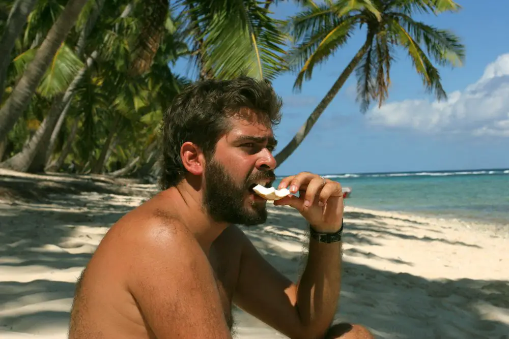 A man eating food for survival in an island