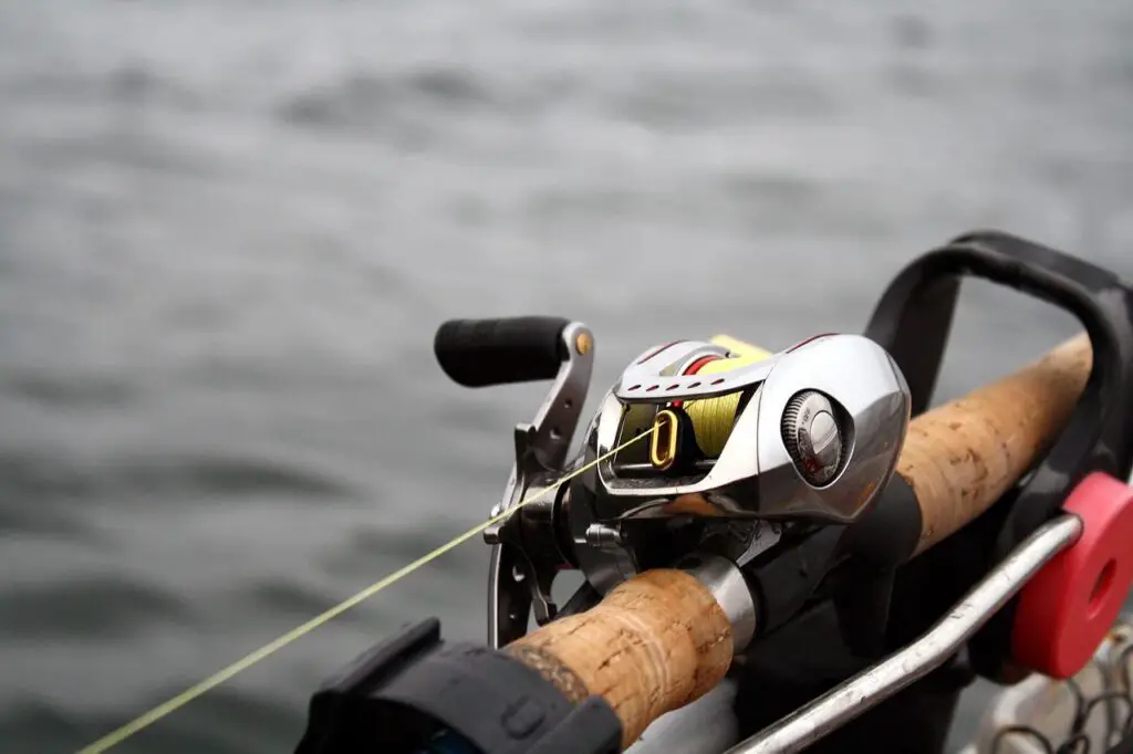 Focused camera shot of a baitcasting reel attached on a fishing rod