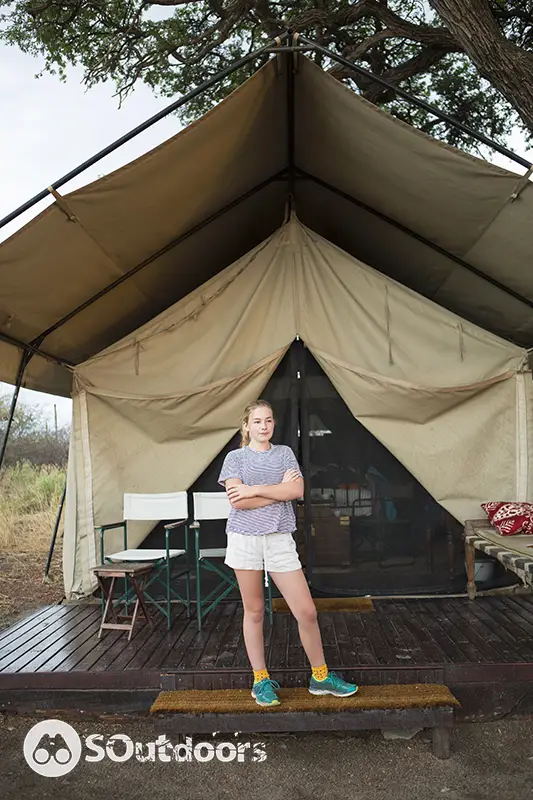 A girl standing in front of a structural tent
