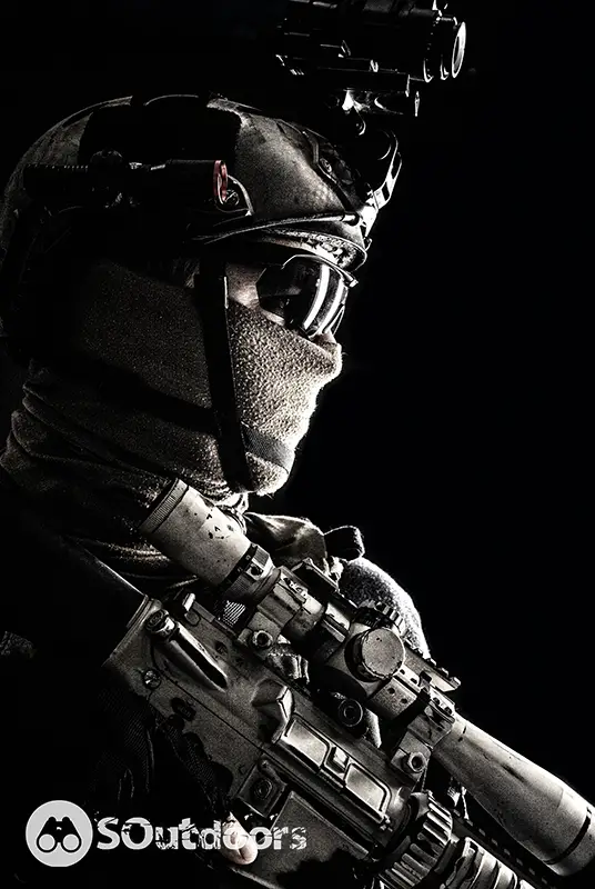 Shoulder portrait of an army elite troop wearing a helmet armed with a rifle equipped an optical scope