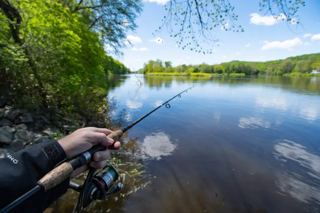 A man holding his fishing rod in the lake