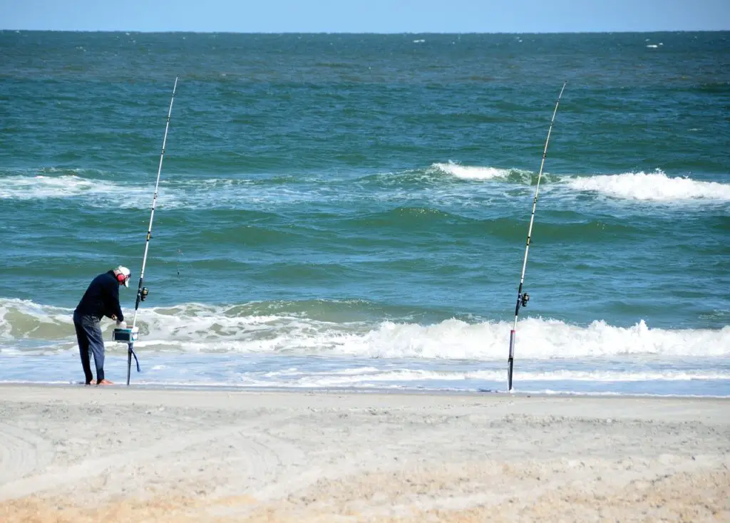 A fisherman setting up his fishing rods near the seashore