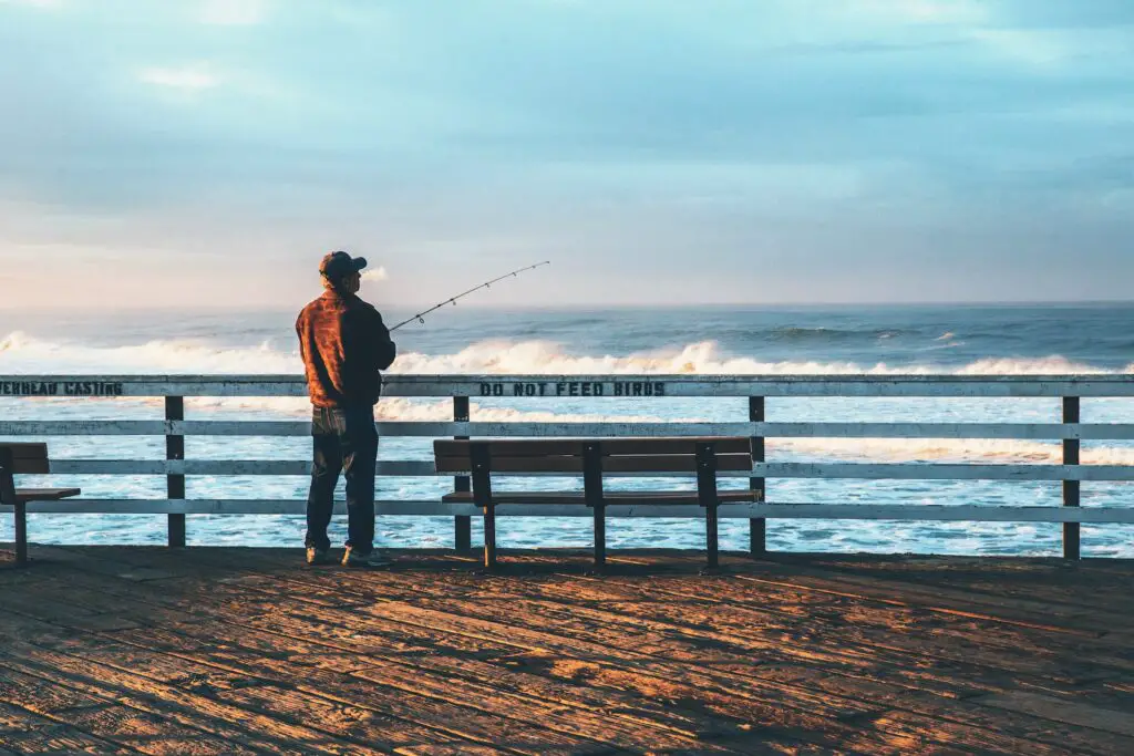 A man holding his fishing rod patiently waiting for his first catch