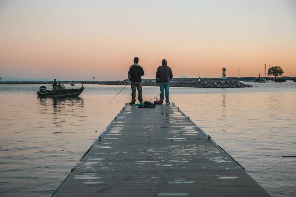 Two men fishing on a boat dock